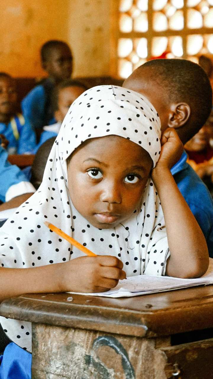 A school pupil writing at a classroom desk