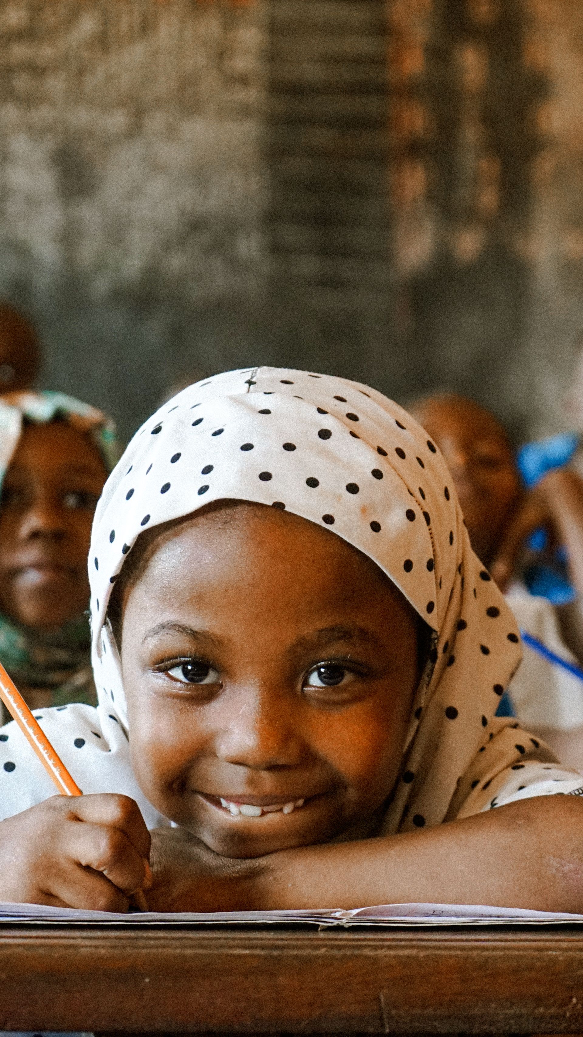 A young African girl with a notebook, smiling